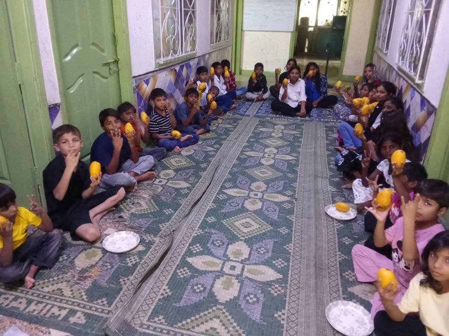 Children seated at a long meal table